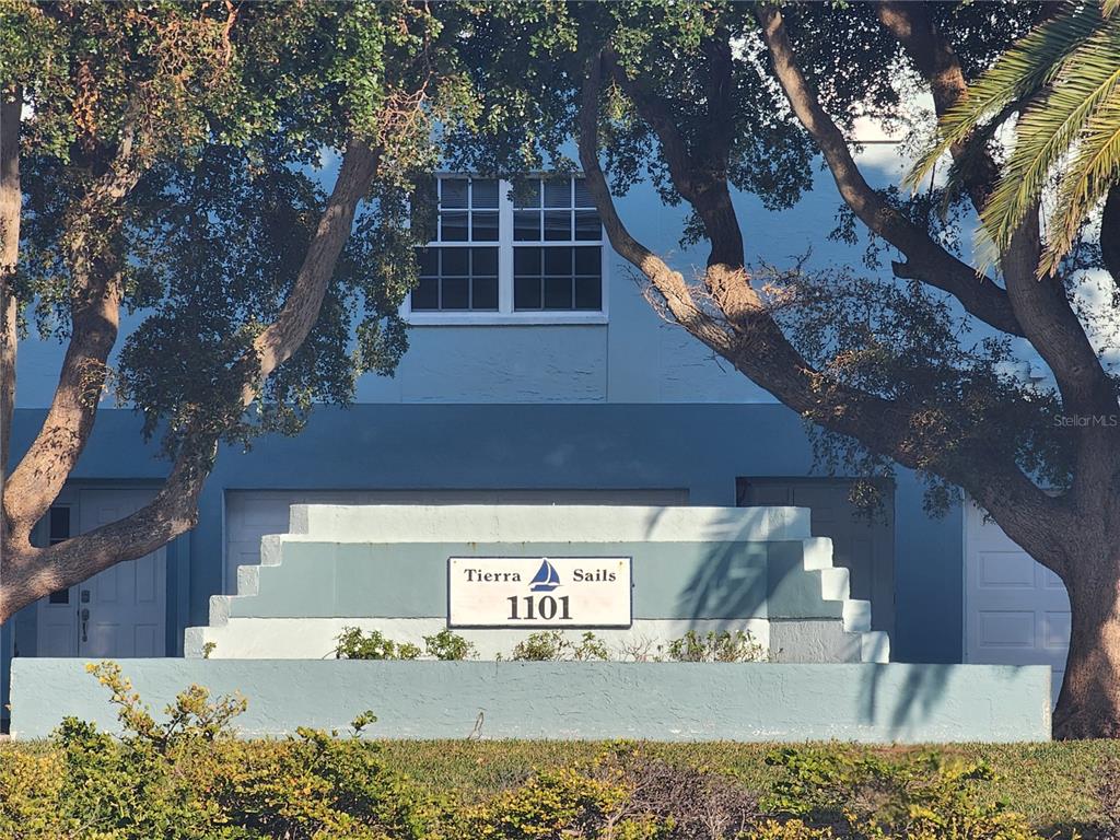 A blue building with a Tierra Sails sign and a white window behind trees — 1101 PINELLAS BAYWAY S UNIT 303, TIERRA VERDE, FL