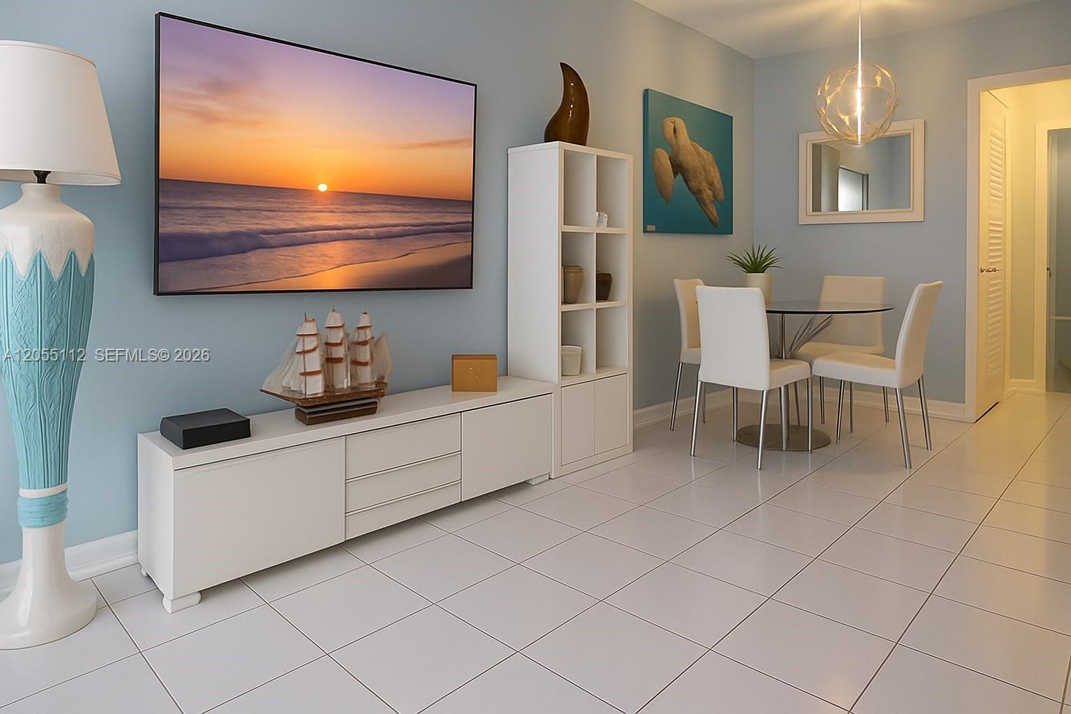 A living and dining area features white tile floors, a television, and white furniture — 901 SW 11th Ave # 4H, Hallandale Beach FL 33009, HALLANDALE BEACH, FL