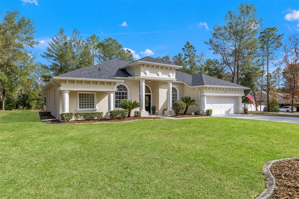 A single-story beige stucco house with a dark shingled roof and a front lawn — 14071 LINDEN DRIVE, SPRING HILL, FL