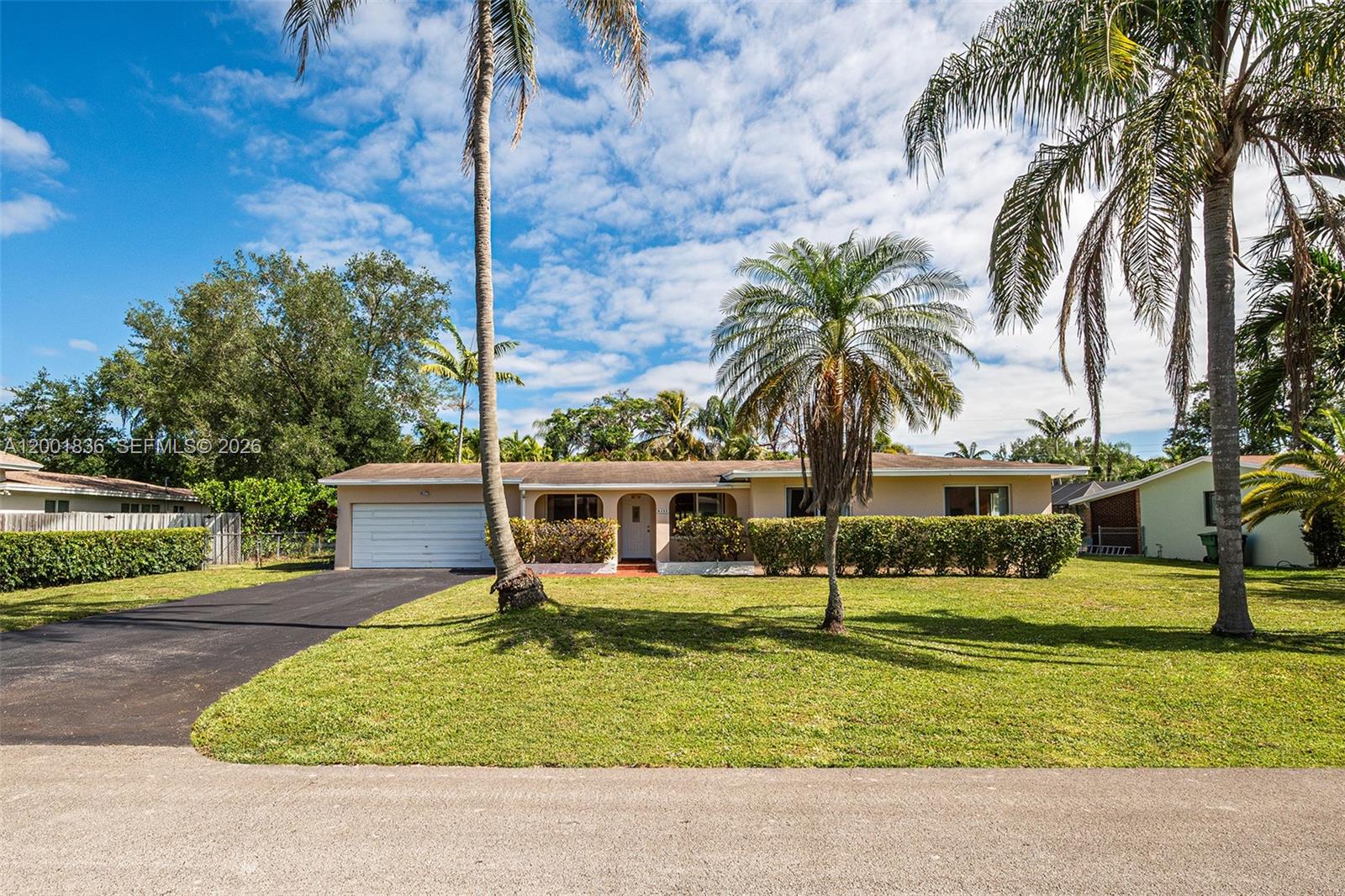A single-story house with a garage, palm trees, and a manicured lawn — 8355 SW 131st St, Pinecrest FL 33156, PINECREST, FL