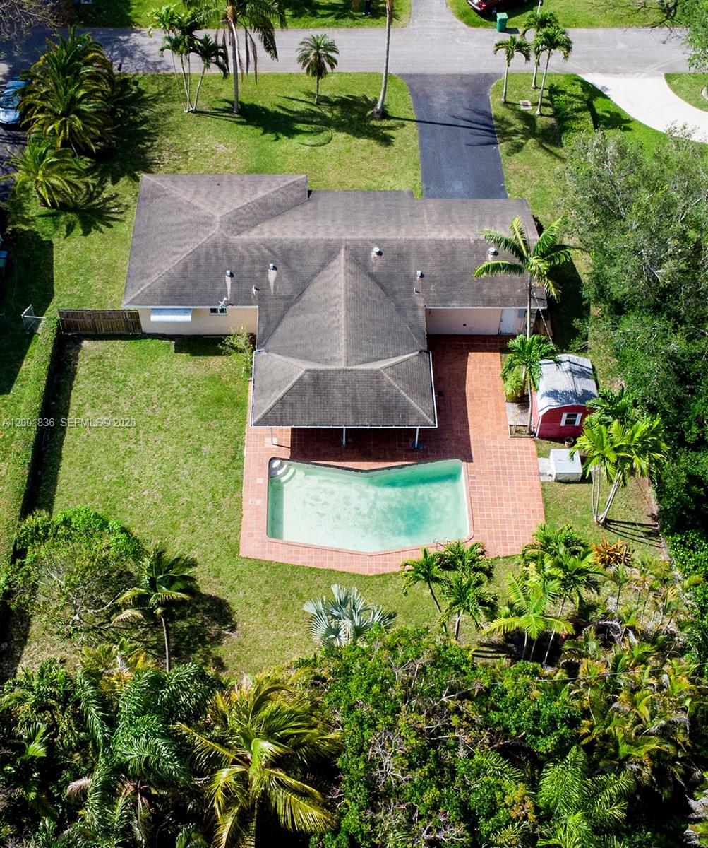 An aerial view shows a house with a shingled roof, pool, patio, and backyard shed — 8355 SW 131st St, Pinecrest FL 33156, PINECREST, FL