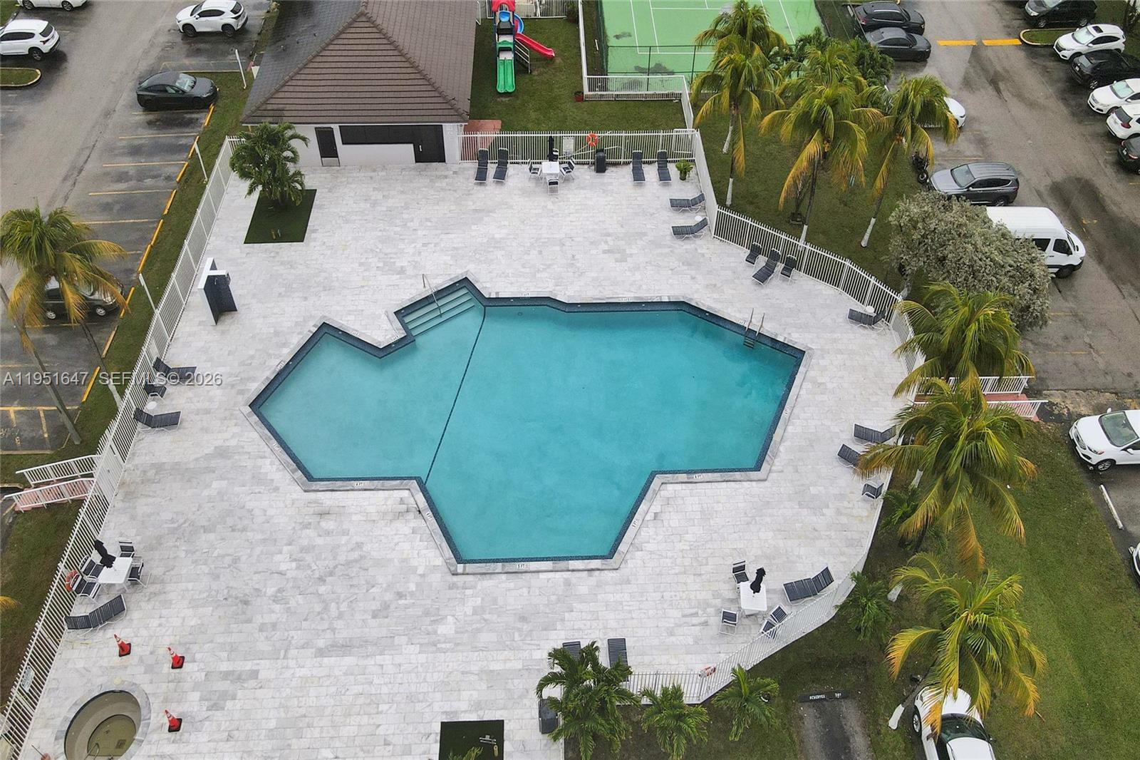 An aerial view shows a swimming pool with a deck, lounge chairs, and surrounding palm trees — 8145 NW 7th St # 315, Miami FL 33126, MIAMI, FL