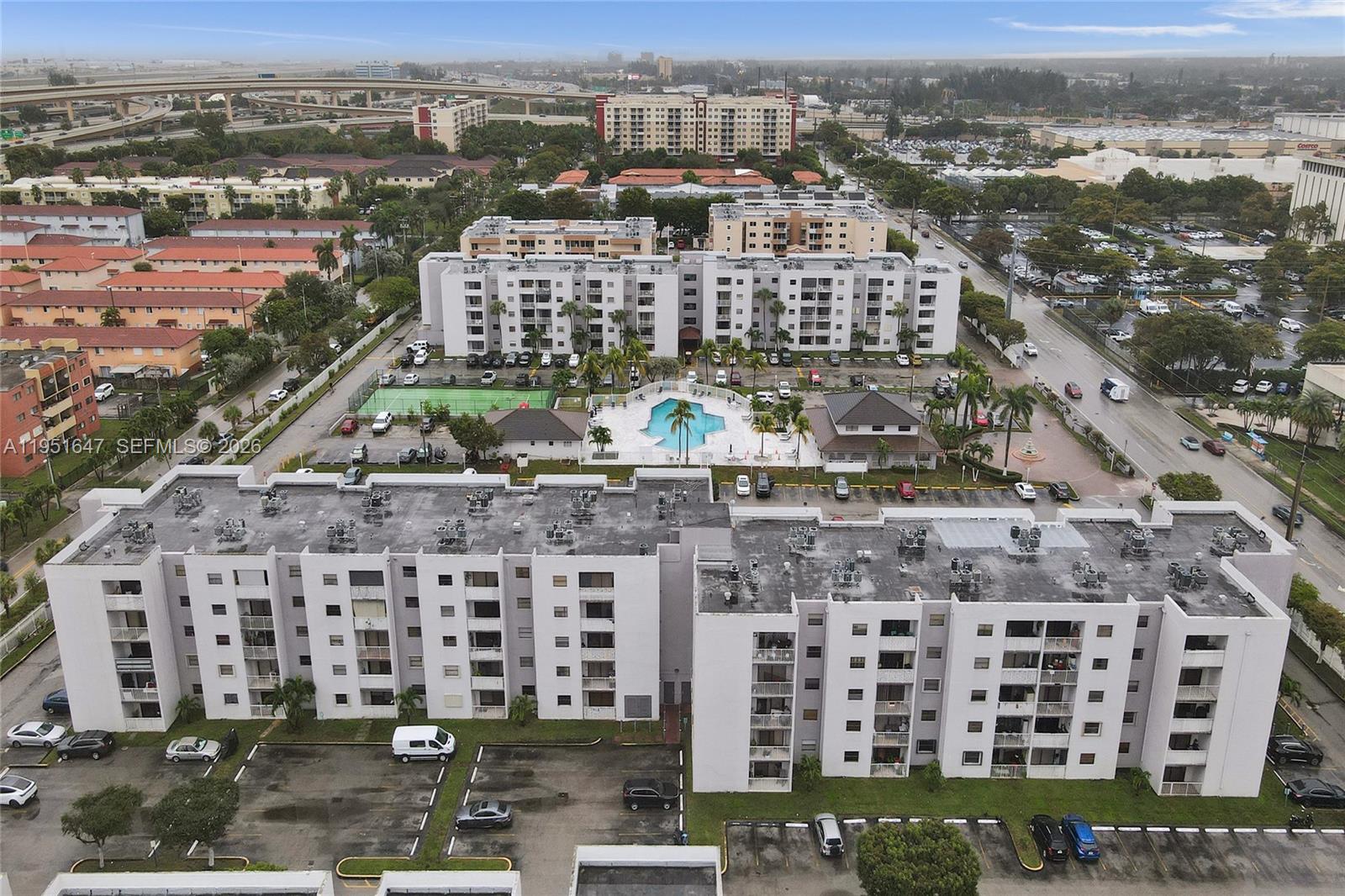 An aerial view shows a multi-story apartment complex with a swimming pool and parking lot — 8145 NW 7th St # 315, Miami FL 33126, MIAMI, FL