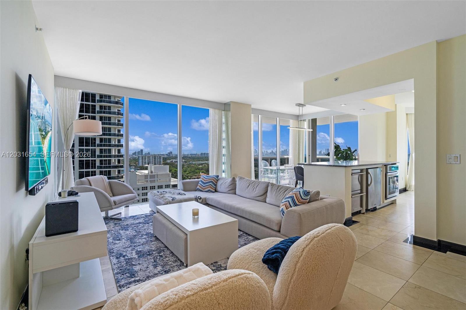 A modern living room features a sectional sofa, a coffee table, and floor-to-ceiling windows — 4779 Collins Ave # 2305, Miami Beach FL 33140, MIAMI BEACH, FL