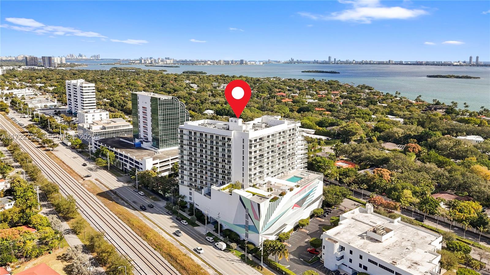 An aerial view shows a white high-rise building with a mural and rooftop pool — 4250 Biscayne Blvd # 1418, Miami FL 33137, MIAMI, FL