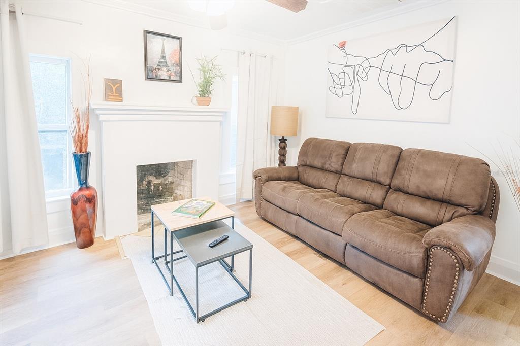 A living room features a brown sofa, a fireplace, and a nesting coffee table — 7105 N 10TH STREET, TAMPA, FL