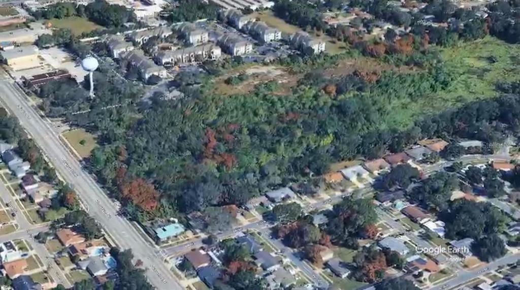 An aerial view shows a wooded lot bordered by residential neighborhoods and a main road — HIAWASSEE ROAD, ORLANDO, FL