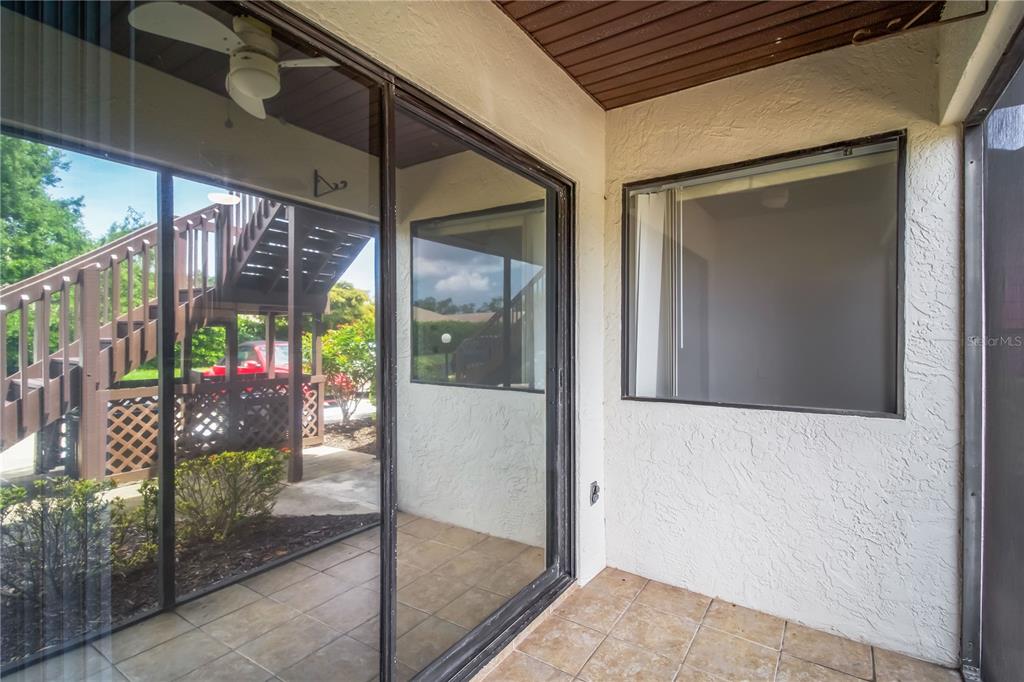 A covered patio features tiled flooring, a ceiling fan, and a sliding glass door — 2715 72ND STREET COURT W, BRADENTON, FL