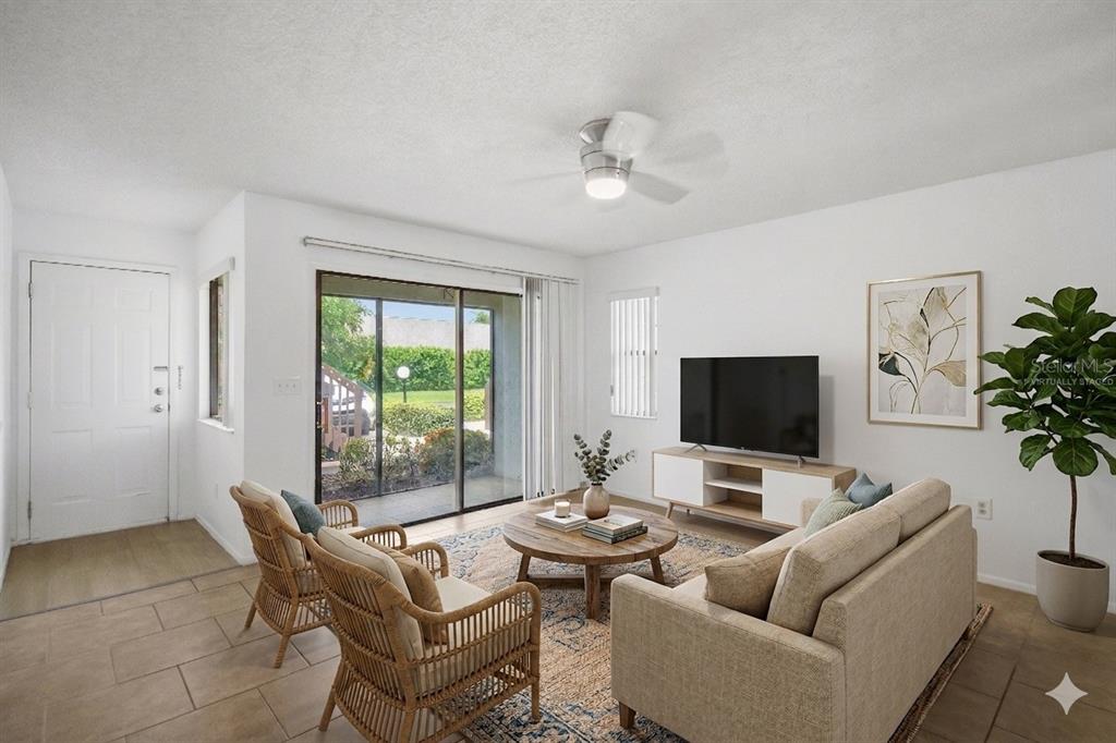 A living room features tile flooring, a sliding glass door, and a ceiling fan — 2715 72ND STREET COURT W, BRADENTON, FL