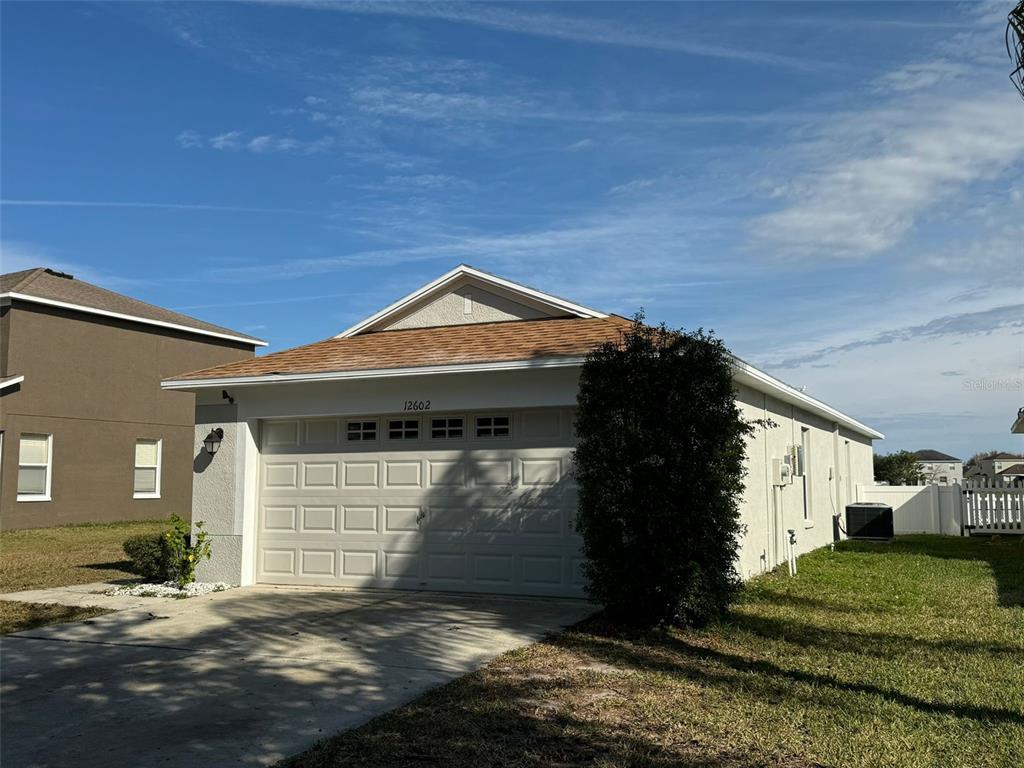 A single-story house with a white garage door and a brown shingled roof — 12602 EVINGTON POINT DRIVE, RIVERVIEW, FL
