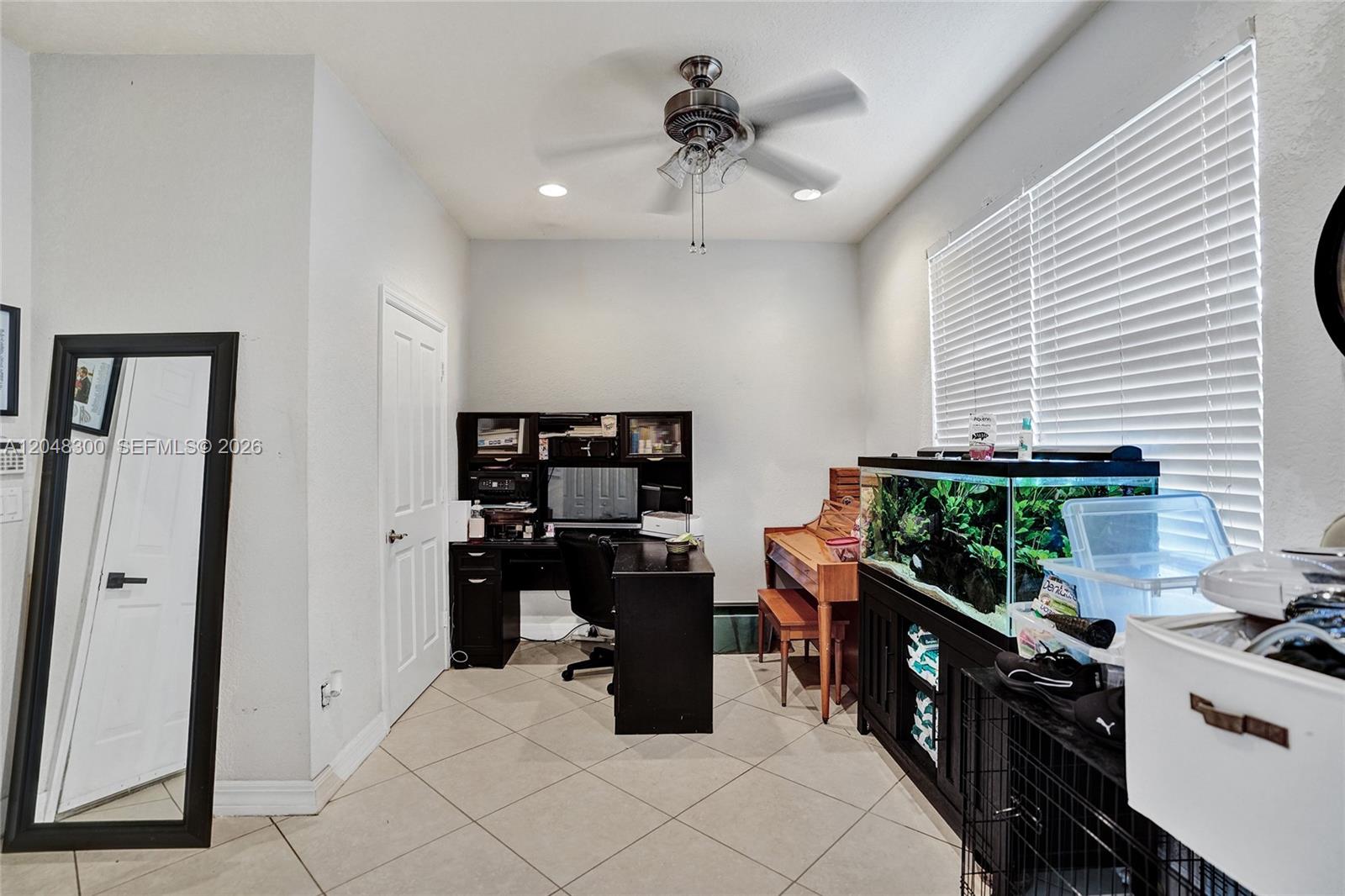 A home office features a desk, a piano, and a large aquarium under a window — 132 Ocean Cay Way, Hypoluxo FL 33462, HYPOLUXO, FL