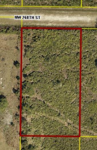 An aerial view shows a rectangular plot of undeveloped land bordering a gravel road — 18188 NW 268th Street, Okeechobee FL 34972, OKEECHOBEE, FL