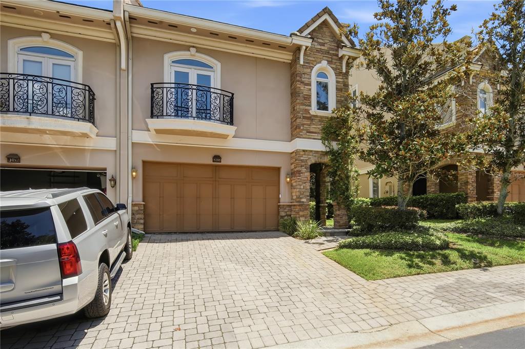 A two-story townhouse with a stone facade, a two-car garage, and a balcony — 1465 HILLSIDE LANDING DRIVE, TARPON SPRINGS, FL