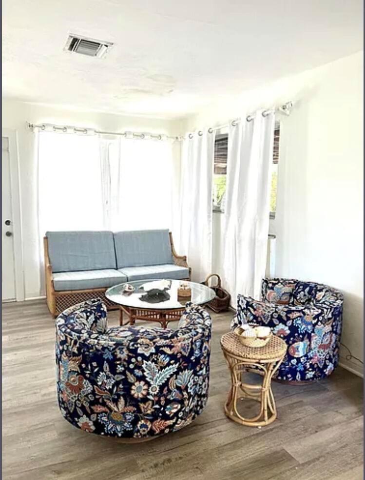 A living room features a wicker sofa, two patterned swivel chairs, and a glass coffee table — 24 SW 12th Street, Dania Beach FL 33004, DANIA BEACH, FL