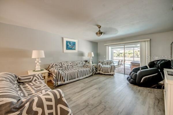A living room features gray patterned furniture, light wood-look flooring, and a sliding glass door — 912 SE 24TH AVENUE UNIT A &  B, CAPE CORAL, FL