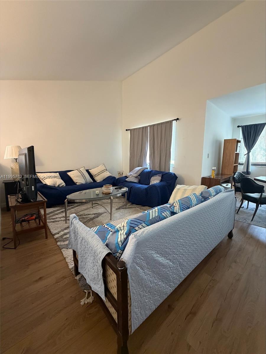 A living room features blue sofas, a glass coffee table, and light wood flooring — 221 W Park Dr # 3, Miami FL 33172, MIAMI, FL