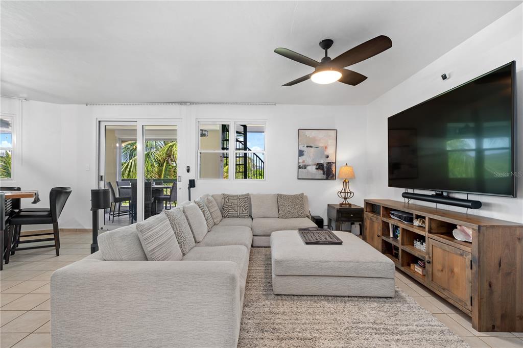 A living room features a large sectional sofa, a television, and a ceiling fan — 155 CANDELERO DRIVE UNIT D7, HUMACAO, PR