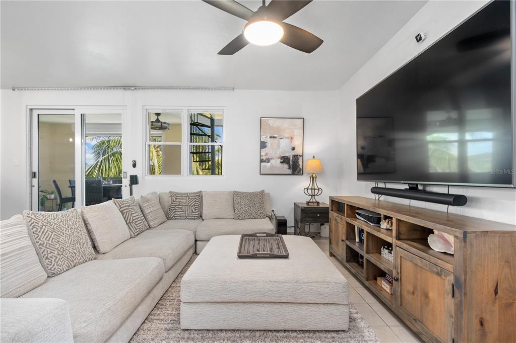 A living room features a large sectional sofa, a central ottoman, and a wall-mounted television — 155 CANDELERO DRIVE UNIT D7, HUMACAO, PR
