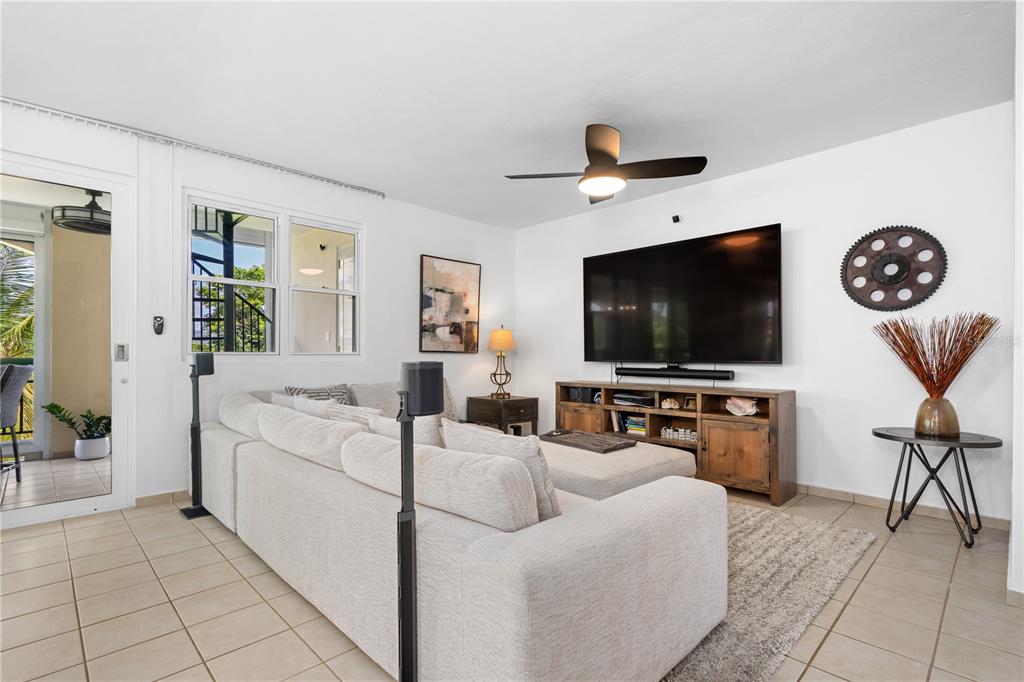 A living room features a large sectional sofa, a wall-mounted television, and tile flooring — 155 CANDELERO DRIVE UNIT D7, HUMACAO, PR