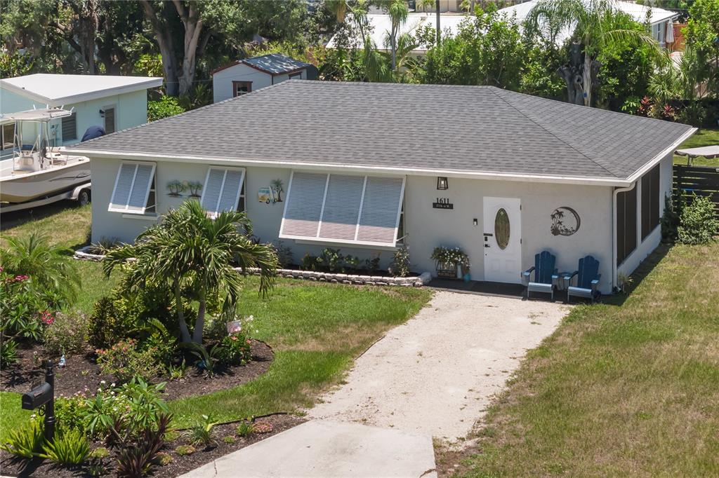 An aerial view of a single-story house with a gravel driveway and a palm tree — 1611 27TH STREET W, BRADENTON, FL