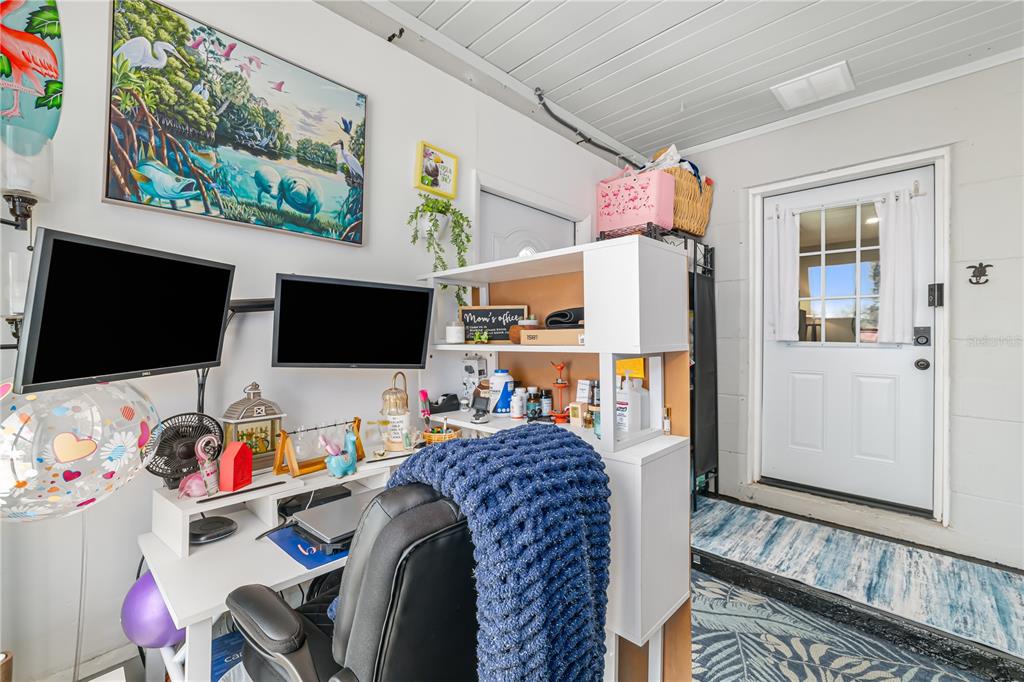 A home office space features a desk with dual monitors, a chair, and a white door — 1611 27TH STREET W, BRADENTON, FL