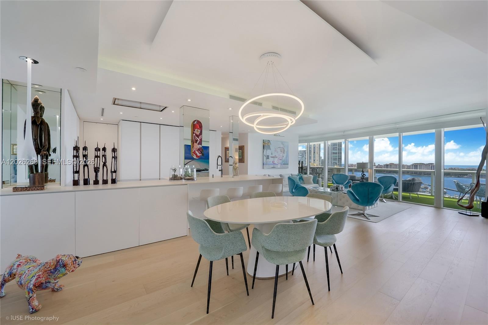 A modern open-concept living and dining area features white cabinetry, light wood floors, and floor-to-ceiling windows — 400 Alton Rd # 1506, Miami Beach FL 33139, MIAMI BEACH, FL