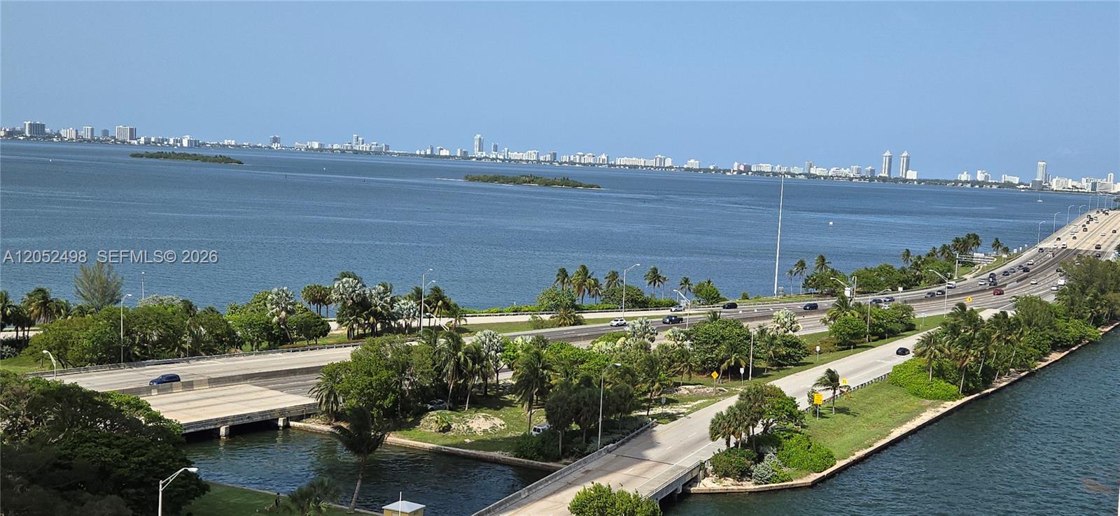 An elevated view shows a highway bridge spanning water with a city skyline in distance — 600 NE 36th St # 1509, Miami FL 33137, MIAMI, FL