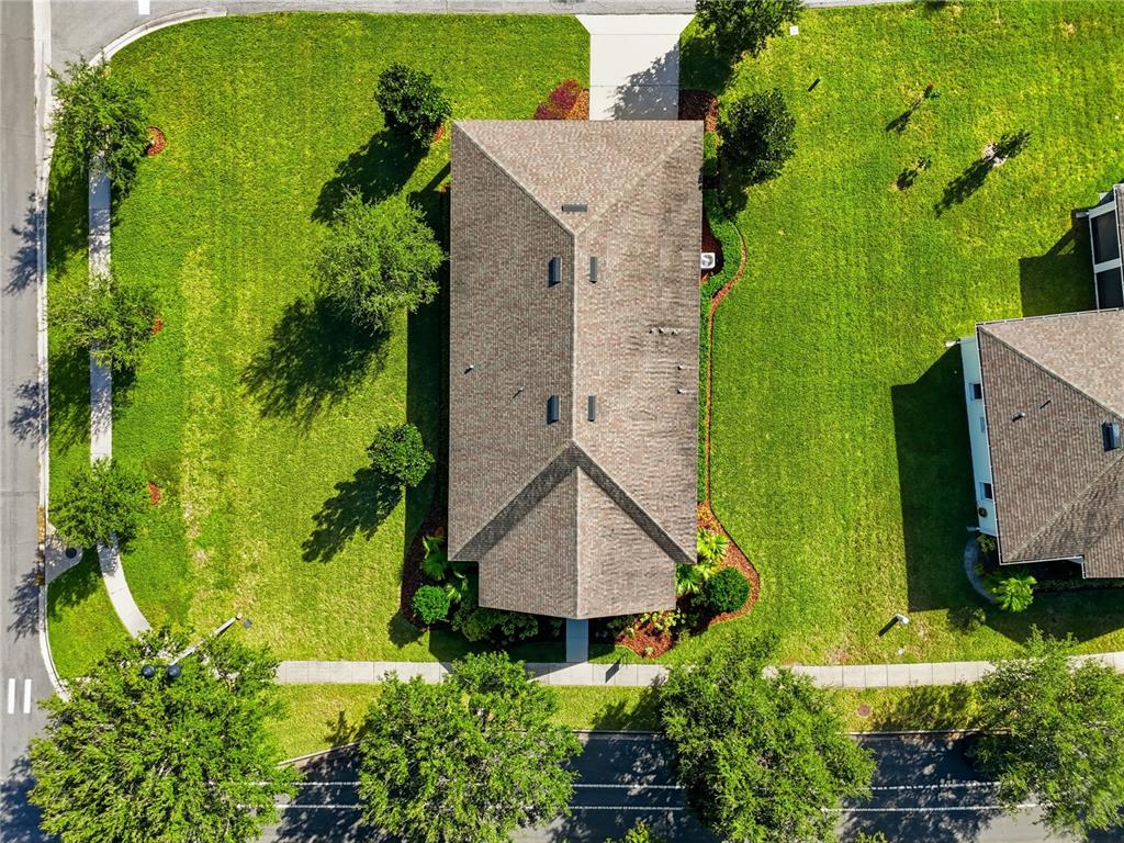 An aerial view shows a house with a shingled roof surrounded by a grassy lawn — 2560 GRASMERE VIEW PARKWAY S, KISSIMMEE, FL