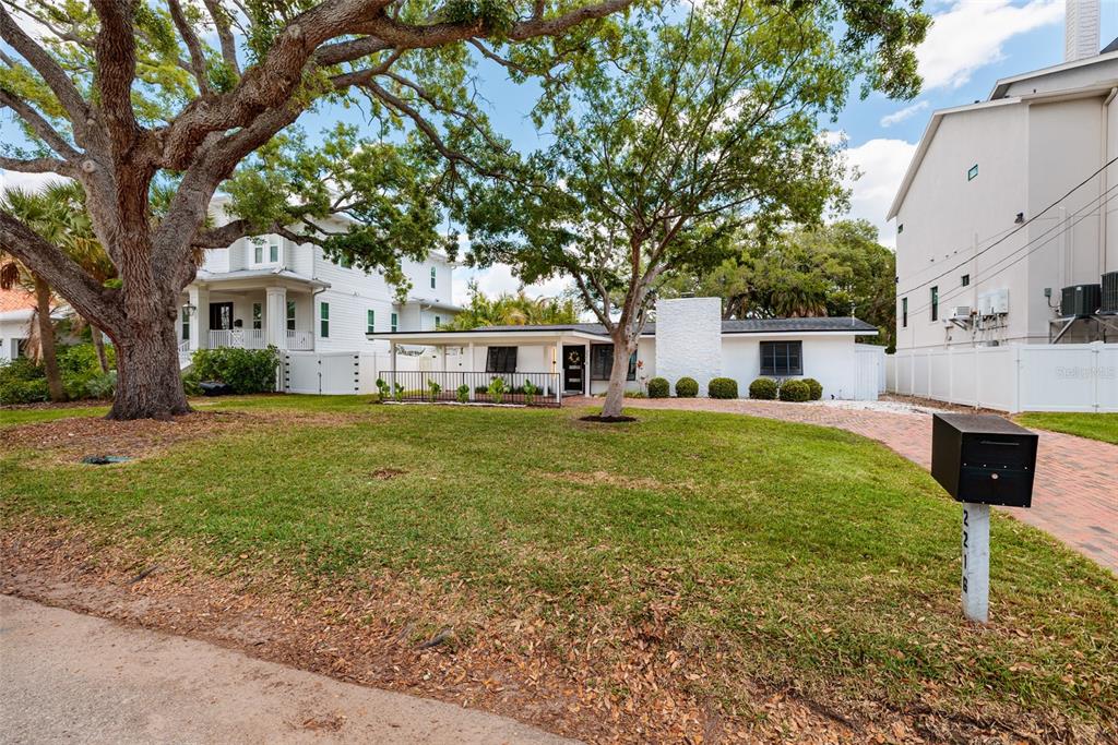 A white single-story house with a brick driveway and large trees in the front yard — 2216 S OCCIDENT STREET, TAMPA, FL