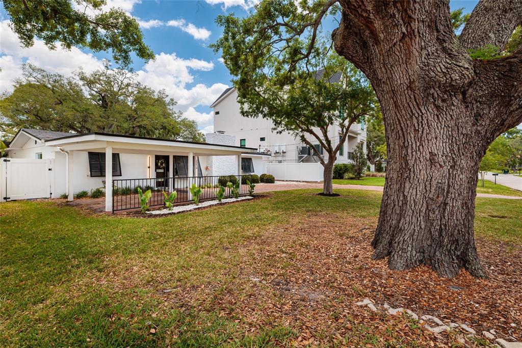 A white house with a covered porch and a large tree in the front yard — 2216 S OCCIDENT STREET, TAMPA, FL