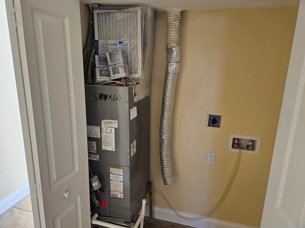 A utility closet contains an HVAC air handler unit and laundry hookups — 2424 W TAMPA BAY BOULEVARD UNIT I102, TAMPA, FL