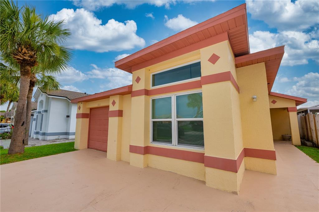 A yellow one-story house with a red-trimmed garage and a palm tree in the yard — 3222 BREWSTER DRIVE, KISSIMMEE, FL