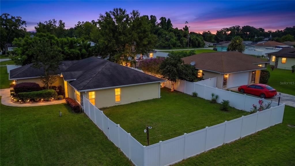 An aerial view of a suburban house with a fenced backyard at sunset — 6765 NW 14TH AVENUE, OCALA, FL