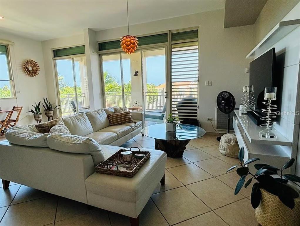A living room features a white sectional sofa, a glass coffee table, and sliding glass doors — 75 OCEAN DRIVE UNIT 341, HUMACAO, PR