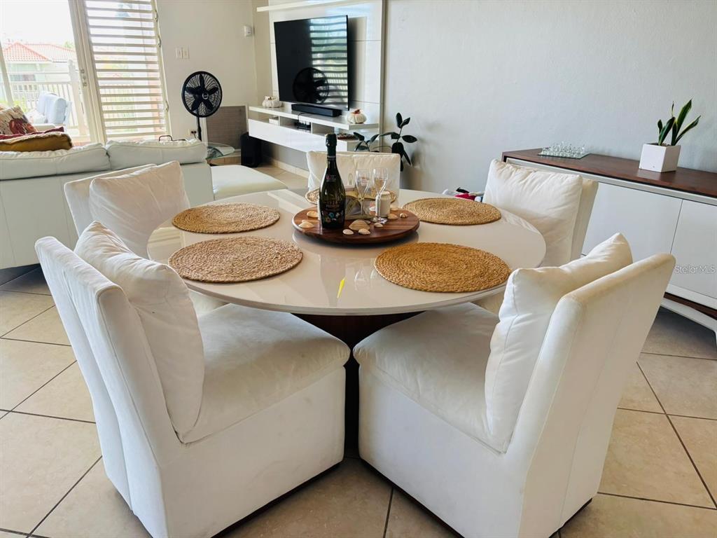 A dining area features a round white table with four upholstered chairs on tiled floors — 75 OCEAN DRIVE UNIT 341, HUMACAO, PR