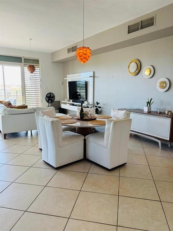 A dining area with a round table and white chairs sits in an open-concept living space — 75 OCEAN DRIVE UNIT 341, HUMACAO, PR