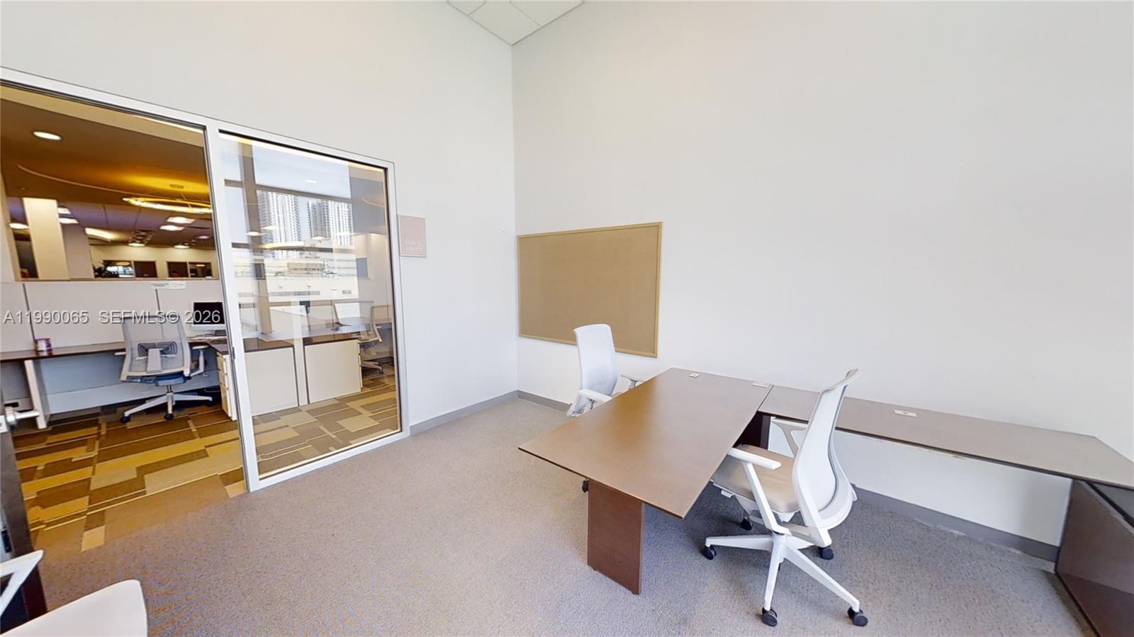 An office room features a desk, two chairs, a corkboard, and a glass wall partition — 1501 Biscayne Blvd # 501W, Miami FL 33132, MIAMI, FL