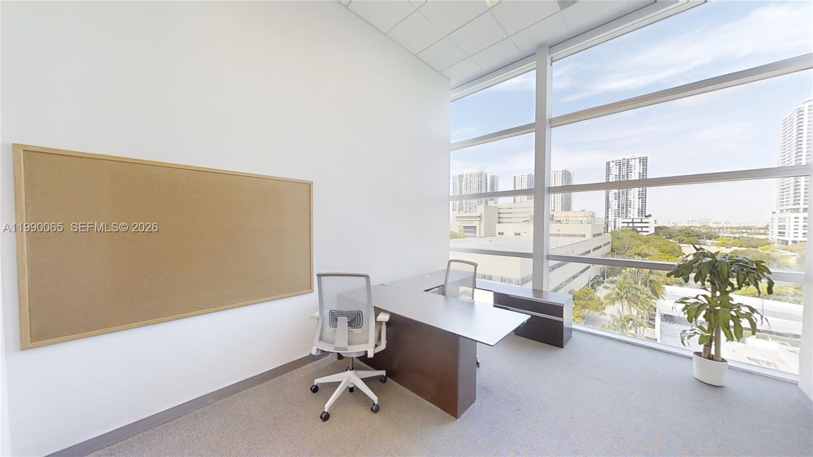 An office features a desk, two chairs, a corkboard, and floor-to-ceiling windows with city views — 1501 Biscayne Blvd # 501W, Miami FL 33132, MIAMI, FL