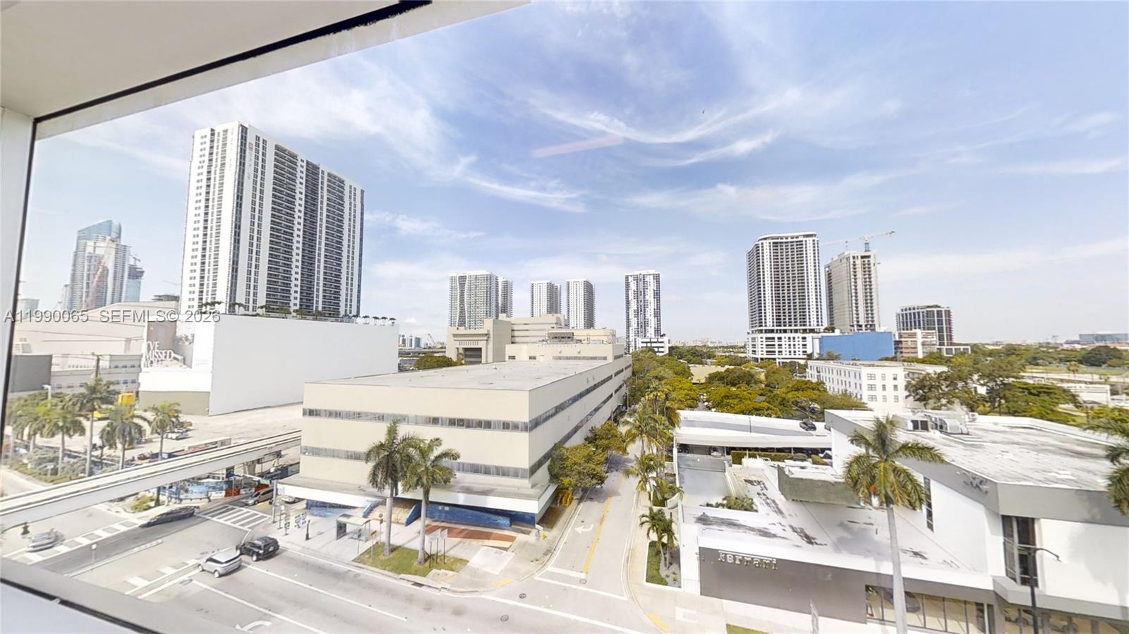 An elevated view shows a city street with palm trees, low-rise buildings, and distant skyscrapers — 1501 Biscayne Blvd # 501W, Miami FL 33132, MIAMI, FL