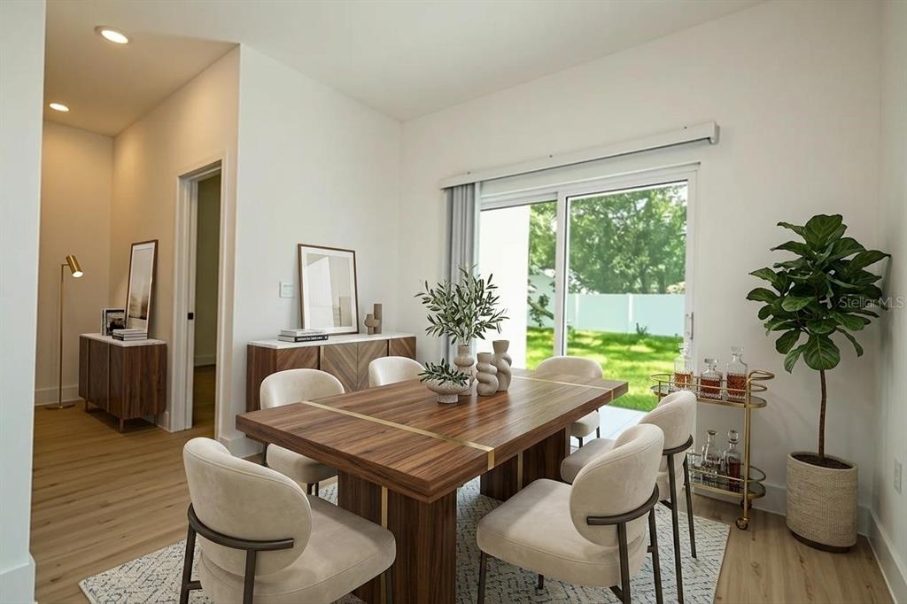 A dining room features a wooden table, cream chairs, a bar cart, and sliding glass doors — 4419 COLLEGE DRIVE, ORLANDO, FL