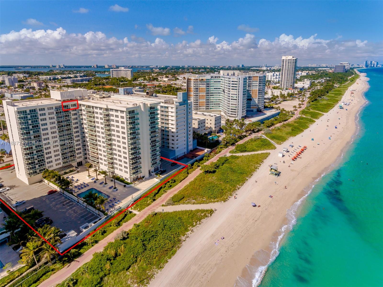 An aerial view shows a beachfront condominium building with a pool and parking area — 6917 Collins Ave, Miami Beach FL 33141, MIAMI BEACH, FL