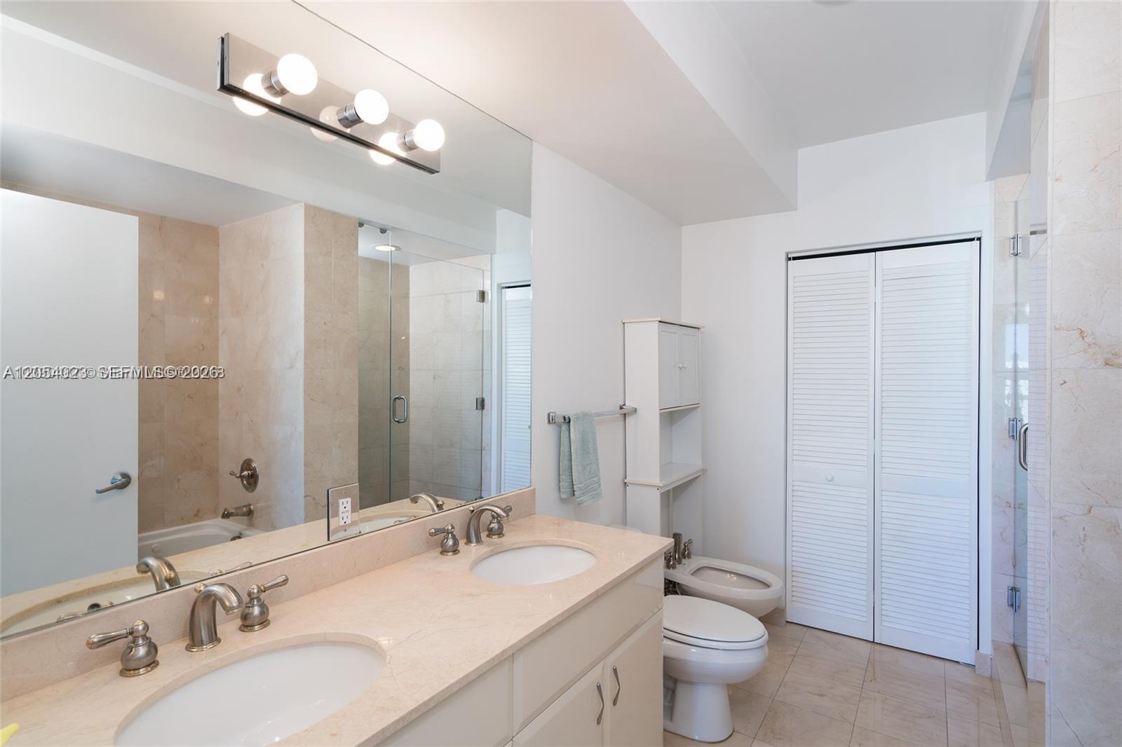 A bathroom features a double vanity with a marble countertop, a toilet, and a bidet — 6365 Collins Ave # 1811, Miami Beach FL 33141, MIAMI BEACH, FL