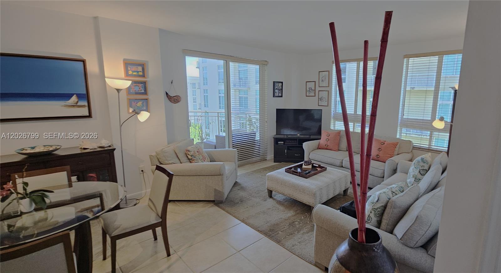 A living room features a beige sofa, matching armchair, ottoman, and a glass dining table — 7350 SW 89th St # 701S, Miami FL 33156, MIAMI, FL