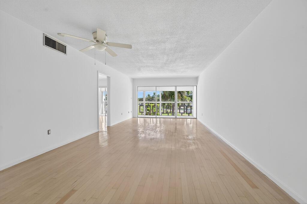 An empty living room with light wood floors, white walls, and a ceiling fan — 331 Tequesta Drive # 224, Tequesta FL 33469, TEQUESTA, FL
