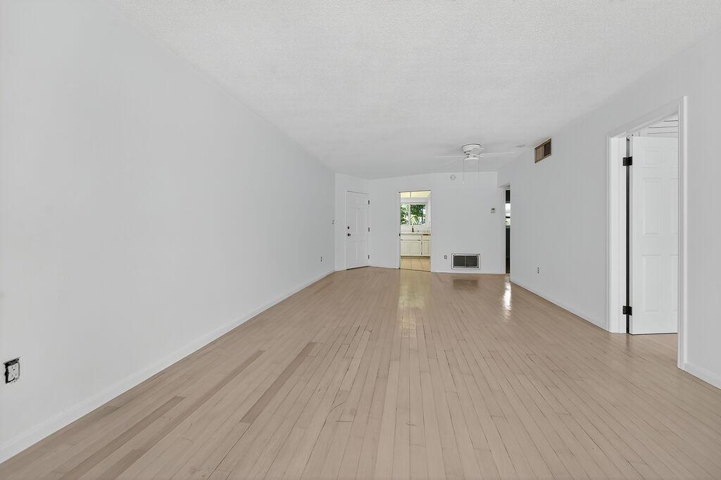 An empty living room features light-colored hardwood floors and plain white walls — 331 Tequesta Drive # 224, Tequesta FL 33469, TEQUESTA, FL