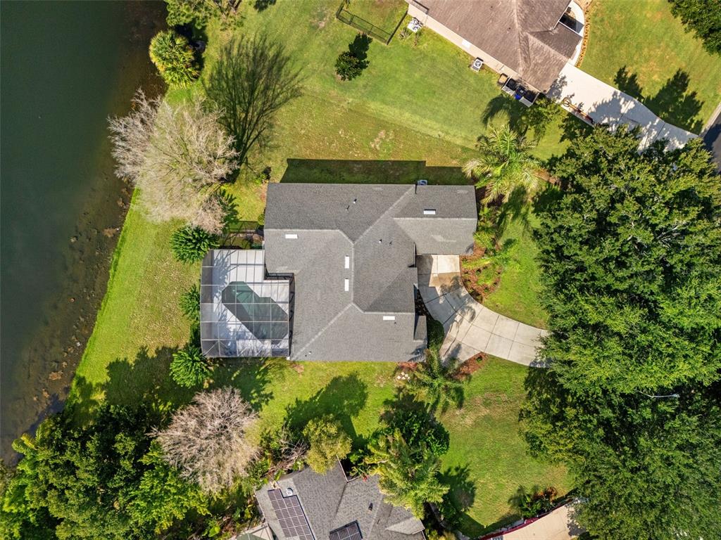 An aerial view shows a house with a screened-in pool and a curved driveway — 5809 GUENEVERE COURT, ST CLOUD, FL