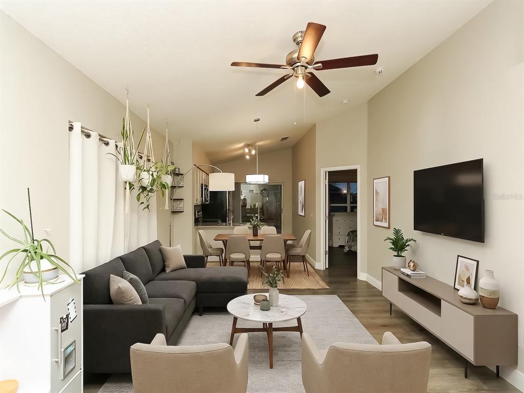 A living room and dining area feature a sectional sofa, ceiling fan, and hardwood floors — 7047 HICKORY BRANCH CIRCLE, ORLANDO, FL