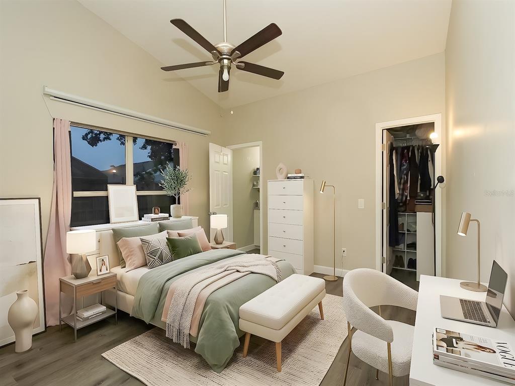 A bedroom with a vaulted ceiling, ceiling fan, bed, desk, and an open closet — 7047 HICKORY BRANCH CIRCLE, ORLANDO, FL