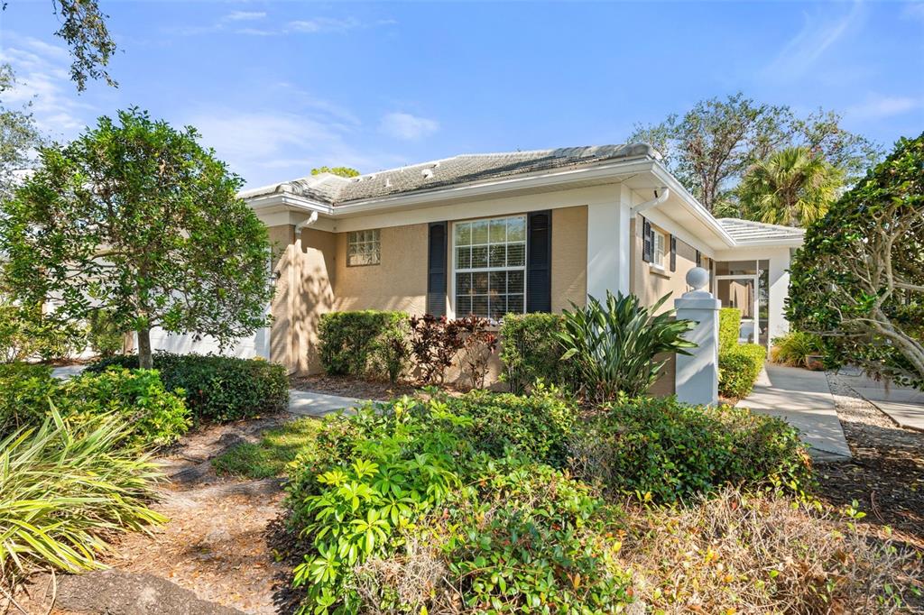 A screened-in porch features a blue and white checkered floor and wicker patio furniture — 905 BARCLAY COURT, VENICE, FL