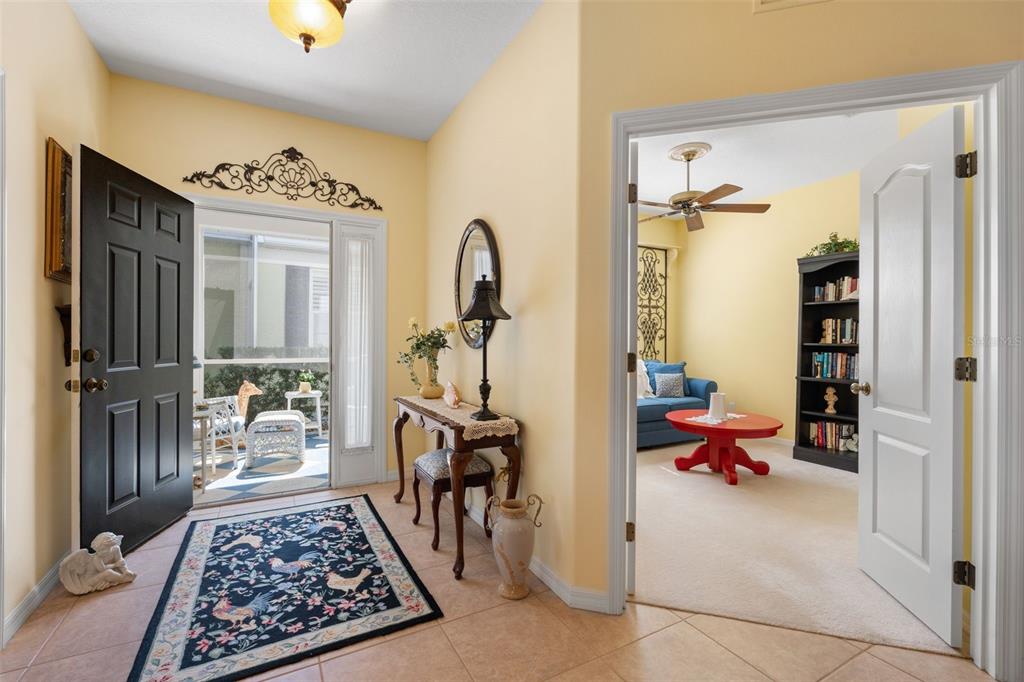 A dining area with a round table, chandelier, and sliding glass doors leading to a lanai — 905 BARCLAY COURT, VENICE, FL